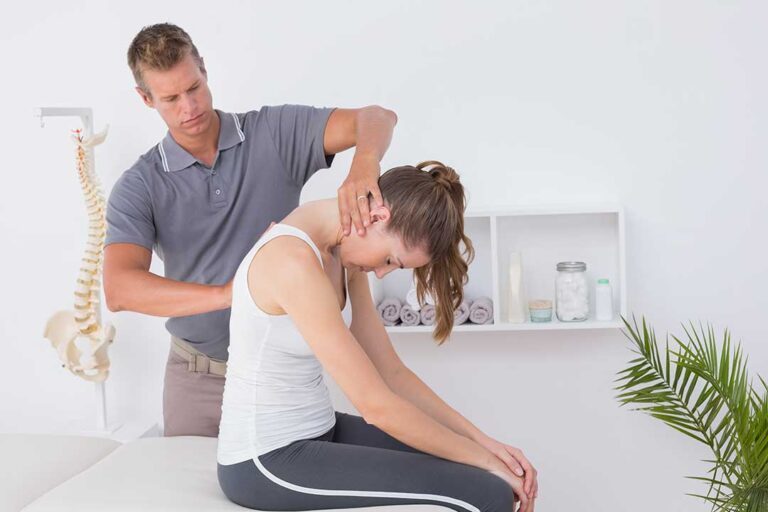 A person using a warm towel compress on their knee while sitting comfortably at home.
